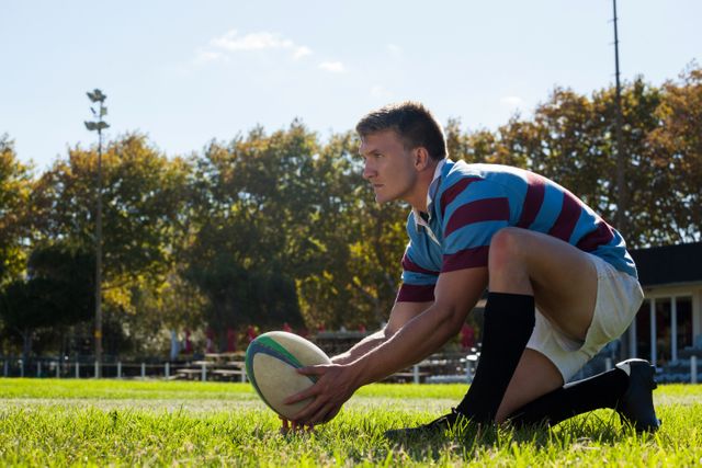 Rugby player in action, preparing to kick for goal on a sunny day. Ideal for sports-related content, athletic training materials, and competitive sports promotions.