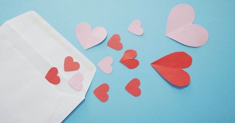Envelope with red and pink hearts for valentine's day on blue background