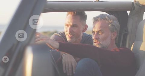 Midlife roadtrip duo pointing horizon from open-roof jeep at golden hour with mail icons