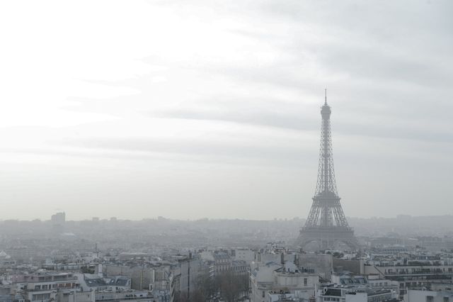 Eiffel Tower amidst hazy Paris skyline on a cloudy day - Download Free Stock Photos Pikwizard.com