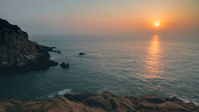 Serene Sunrise Over Calm Ocean With Rocky Coastline - Download Free Stock Photos Pikwizard.com