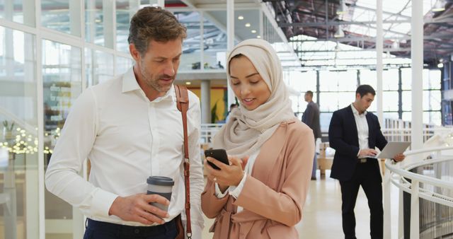 Businessman and Businesswoman in Hijab Collaborating in Modern Office - Download Free Stock Images Pikwizard.com