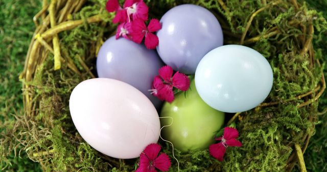 Pastel-colored Easter eggs are nestled in a bed of green moss, adorned with vibrant pink flowers, with copy space. Easter eggs symbolize new life and rebirth, and this arrangement captures the essence of the springtime holiday.