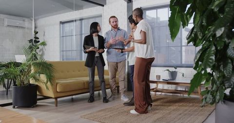 Colleagues celebrating team success in modern office lounge area
