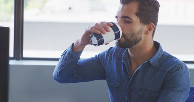 Man Drinking Coffee at Work Desk in Office Setting - Download Free Stock Images Pikwizard.com