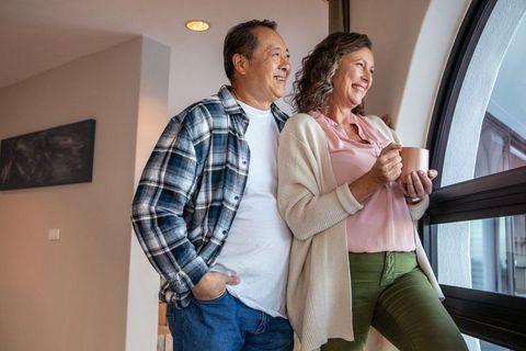 Happy couple enjoying a cozy morning by sunny window
