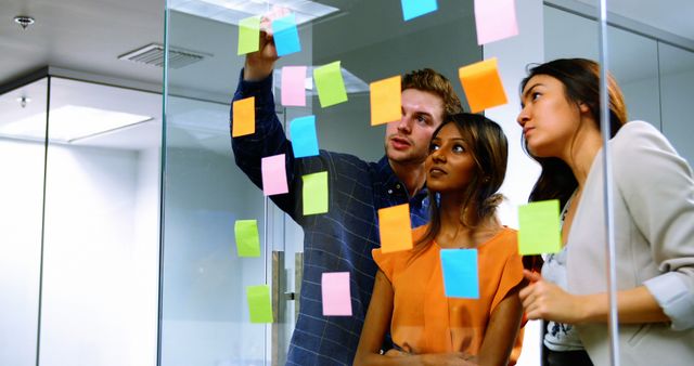 Team brainstorming ideas with sticky notes on glass - Download Free Stock Images Pikwizard.com