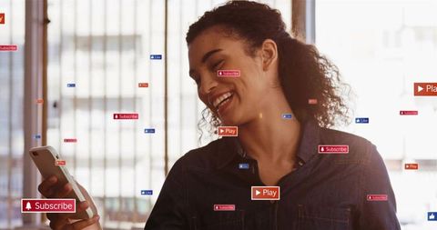 Smiling woman holding smartphone with floating subscribe play like overlays for streaming content