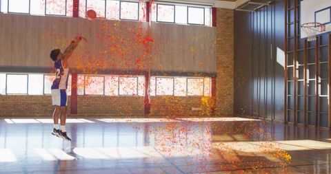 Basketball player making dynamic celebratory shot with confetti