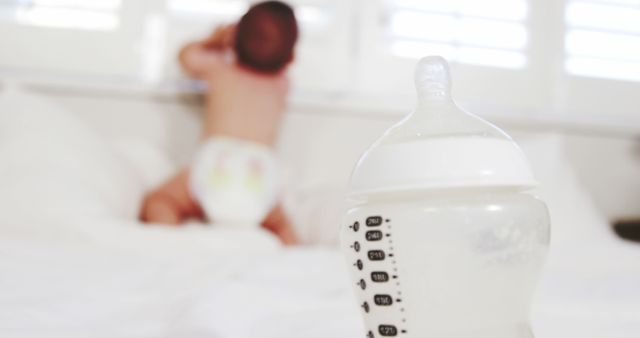 Baby Crawling with Milk Bottle in Foreground on Bed - Download Free Stock Images Pikwizard.com