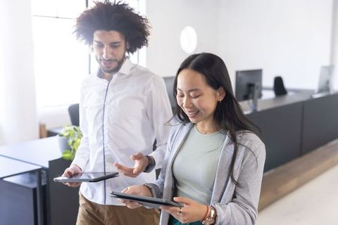 Diverse Coworkers Collaborating with Digital Tablets in Modern Office
