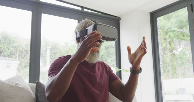 Mature man experiencing virtual reality at home - Download Free Stock Images Pikwizard.com