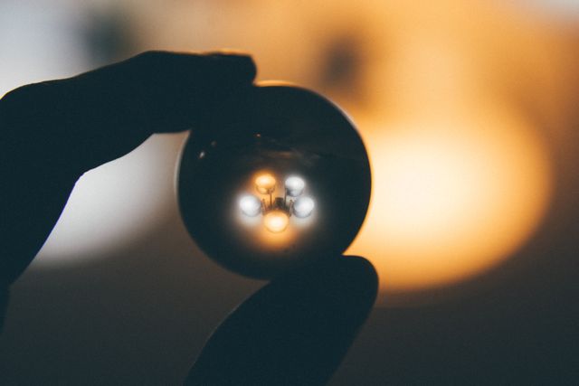 Person Holding Transparent Ball with Reflection of Light Bulbs - Download Free Stock Photos Pikwizard.com