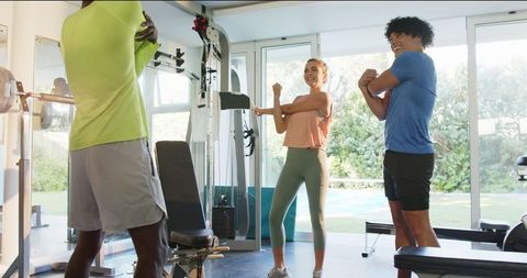 Young adults exercising with personal trainer in home gym