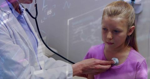 Pediatrician listening to young girl's heart with stethoscope during routine checkup