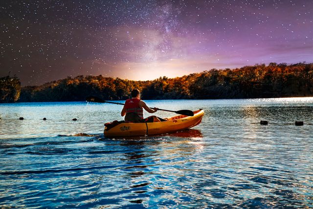 Person kayaking on lake under starry night sky - Download Free Stock Photos Pikwizard.com