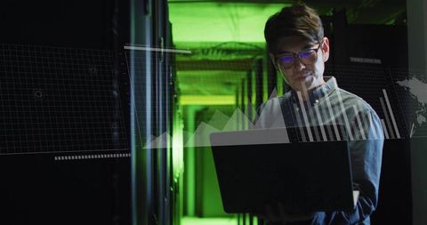 Korean it engineer monitoring servers in green data center with laptop and hud analytics
