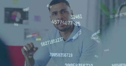 Businessman engaged in data-driven discussion with digital floating numbers