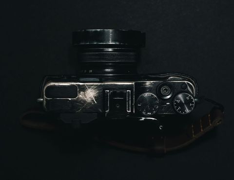 Vintage camera on dark background showing lens and controls