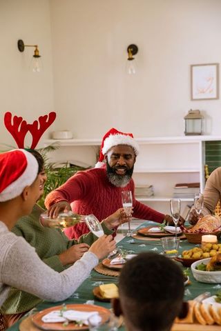 Festive holiday gathering with friends pouring champagne