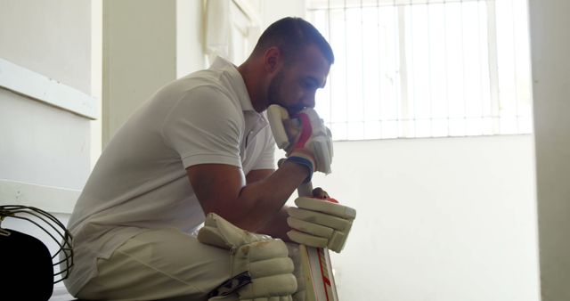 Cricketer Sitting in White Locker Room Reflecting with Gear - Download Free Stock Images Pikwizard.com