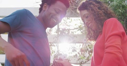 Couple celebrating marriage proposal outdoors