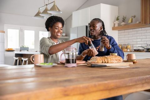 Joyful African American Couple Preparing Breakfast Together in Kitchen