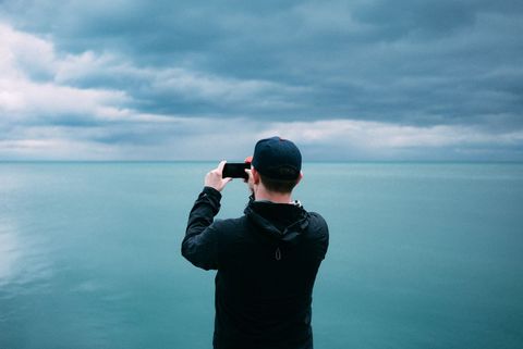 Scenic photography male tourist capturing ocean view