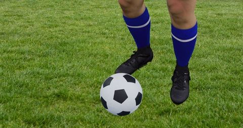 Soccer Player Dribbling Ball on Grass