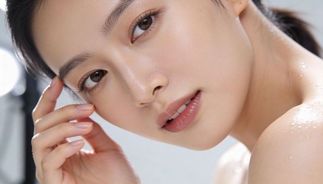 Dewy skincare closeup of asian woman touching temple, glowing skin, beauty portrait studio