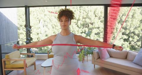Woman pulling resistance band in sunlit modern living room with ar fitness overlays