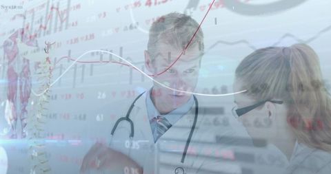 Physician consulting colleague with spinal model, analyzing digital charts and data overlays