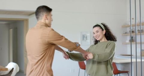Playful Couple Dancing in Modern Dining Area