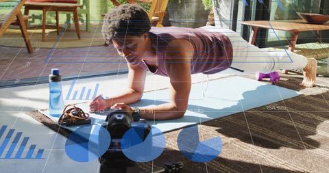 Young man performing forearm plank at-home workout with camera and fitness analytics