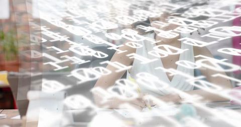 Woman writing with projected typography overlay on home desk, double exposure creative concept