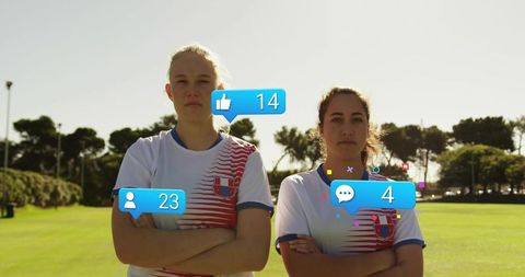 Standing female athletes crossing arms on sunlit team field with social media overlays