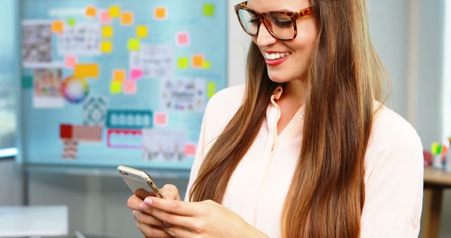 Smiling Woman with Smartphone in Creative Office Space - Download Free Stock Images Pikwizard.com