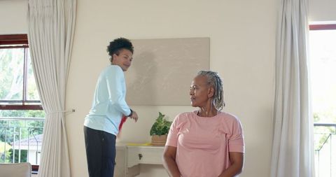 Senior Woman Exercising with Personal Trainer Using Resistance Band