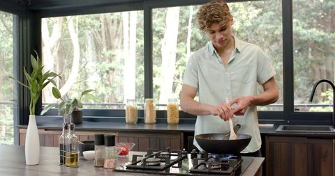 Young Man Cooking in Sleek Modern Kitchen