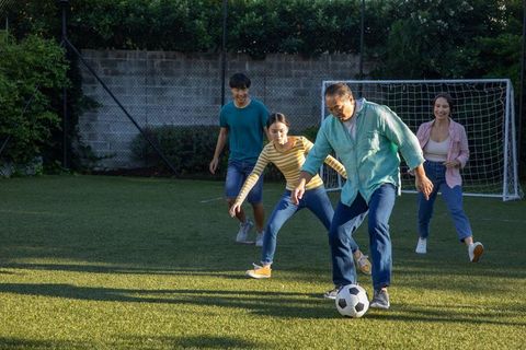 Family enjoying soccer game on outdoor grass field together