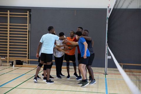 African american volleyball team huddling on indoor court showing teamwork and focus