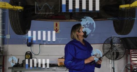 Automotive technician using tablet under lifted car viewing augmented reality diagnostics