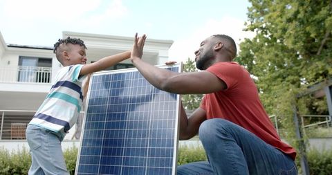 Father and Son Teamwork with Solar Panel Sustainable Energy Concept