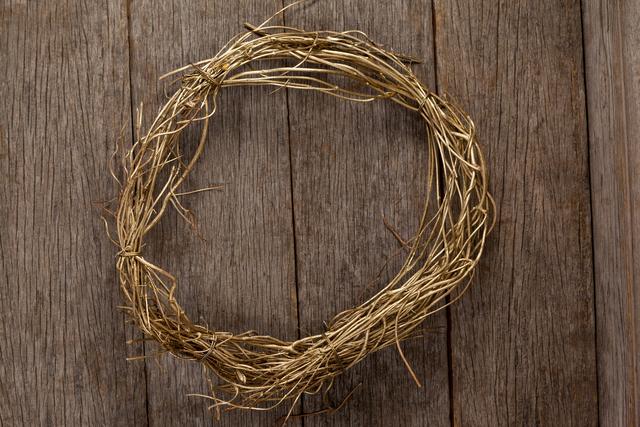 This image features a close-up of a rustic grapevine wreath placed on a wooden plank. Ideal for use in DIY craft tutorials, home decor inspiration, autumn and seasonal decoration themes, and farmhouse style promotions. Perfect for blogs, social media posts, and websites focused on handmade crafts and eco-friendly living.