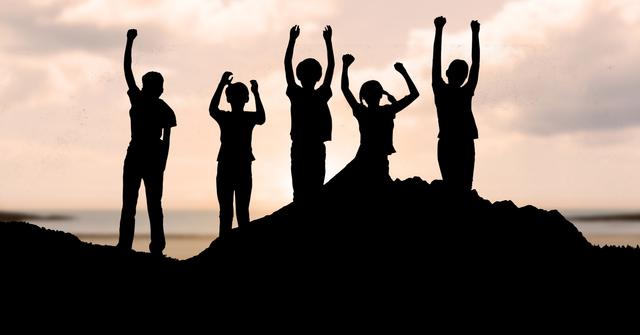 Digital composite of Silhouette people with arms raised standing on mountain
