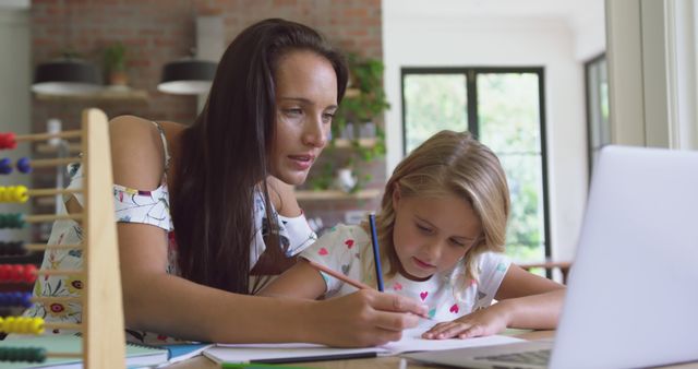 Mother assisting daughter with homework at home - Download Free Stock Images Pikwizard.com