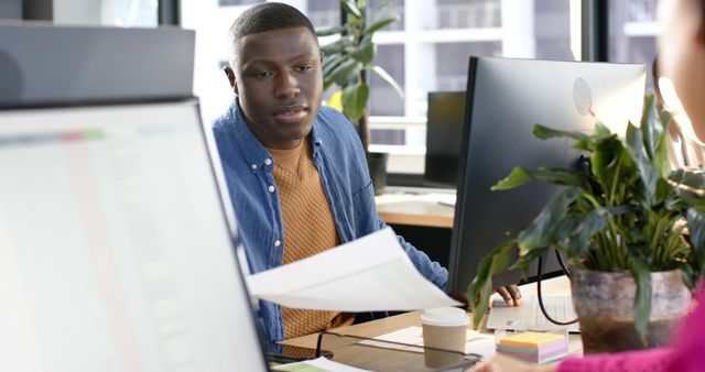 African american businessman using computer in office, copy space. Casual business, office, work, professionals concept, unaltered.