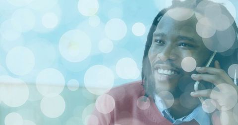 Smiling Mid Adult Man Chatting on Smartphone With Bokeh Overlay