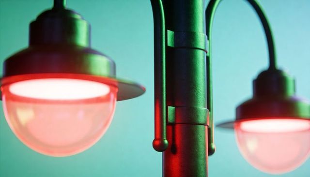 Vintage industrial metal street lamp casting red and green glow with frosted glass globes