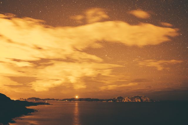 Starlit Coastal Night with Glowing Clouds and Distant Islands - Download Free Stock Photos Pikwizard.com